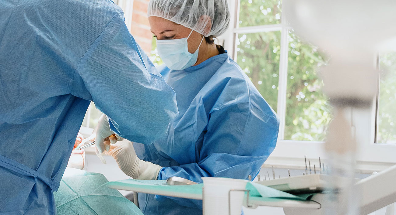 Chirurgisch team voert een implantaatbehandeling uit in de moderne behandelruimte van Grens Implantaat Centrum.